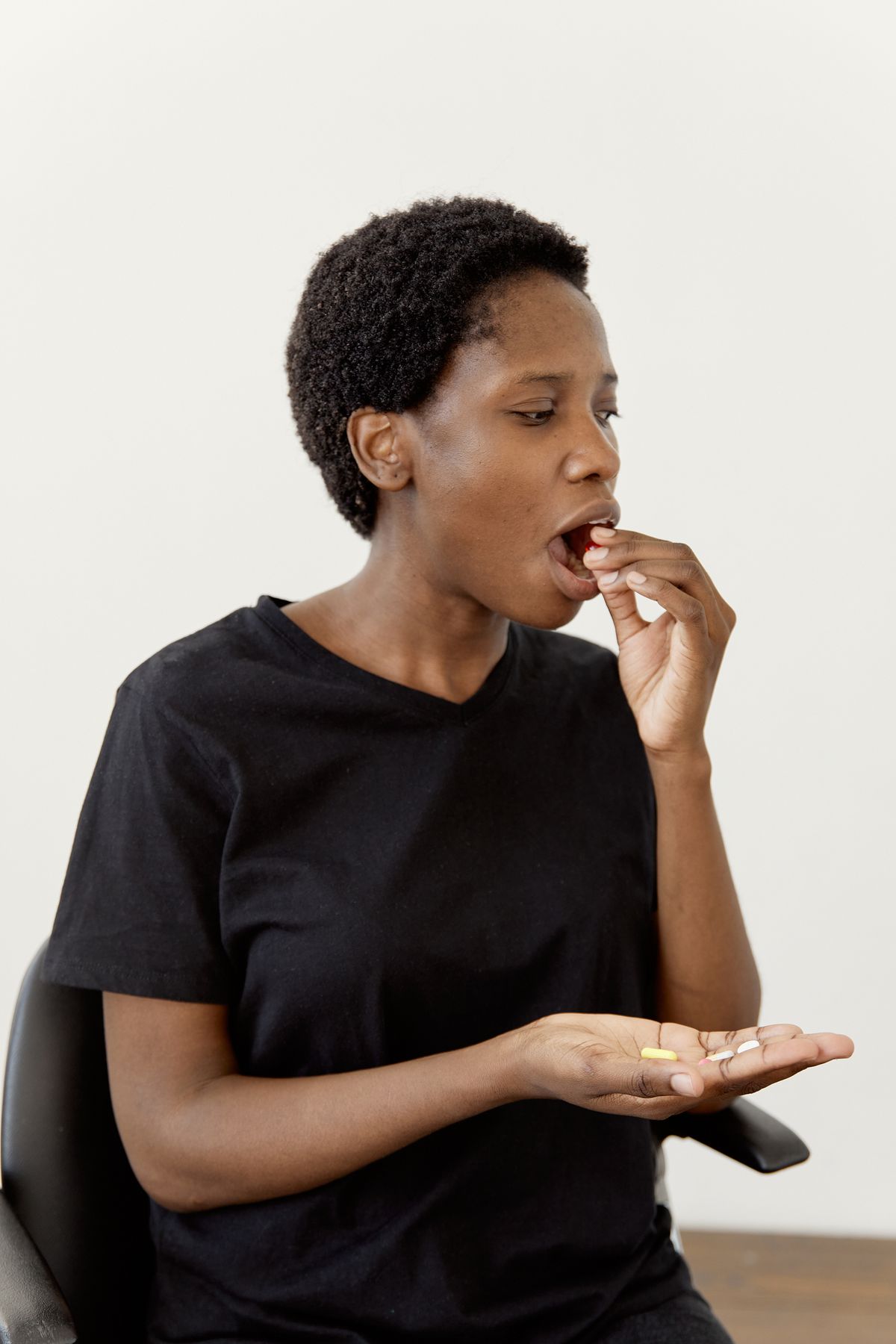 Femme africaine portant un comprimé à sa bouche